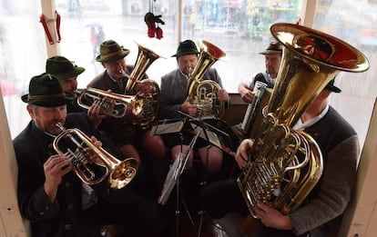 Músicos de instrumentos de viento tocan junto a un paseo bávaro de una feria durante el último día del Oktoberfest en Múnich (Alemania).