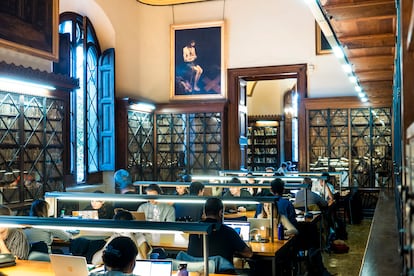 Una de las salas de la biblioteca del edificio histórico de la UB, con la pintura "Cristo en la piedra fría", de Eugenio Cajes, al fondo.