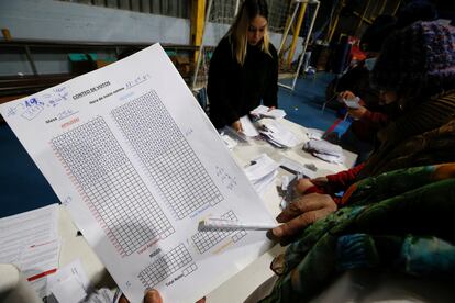 Una funcionaria cuenta los votos del "apruebo" y el "rechazo" en una hoja de registro electoral, en un colegio en Valparaíso.