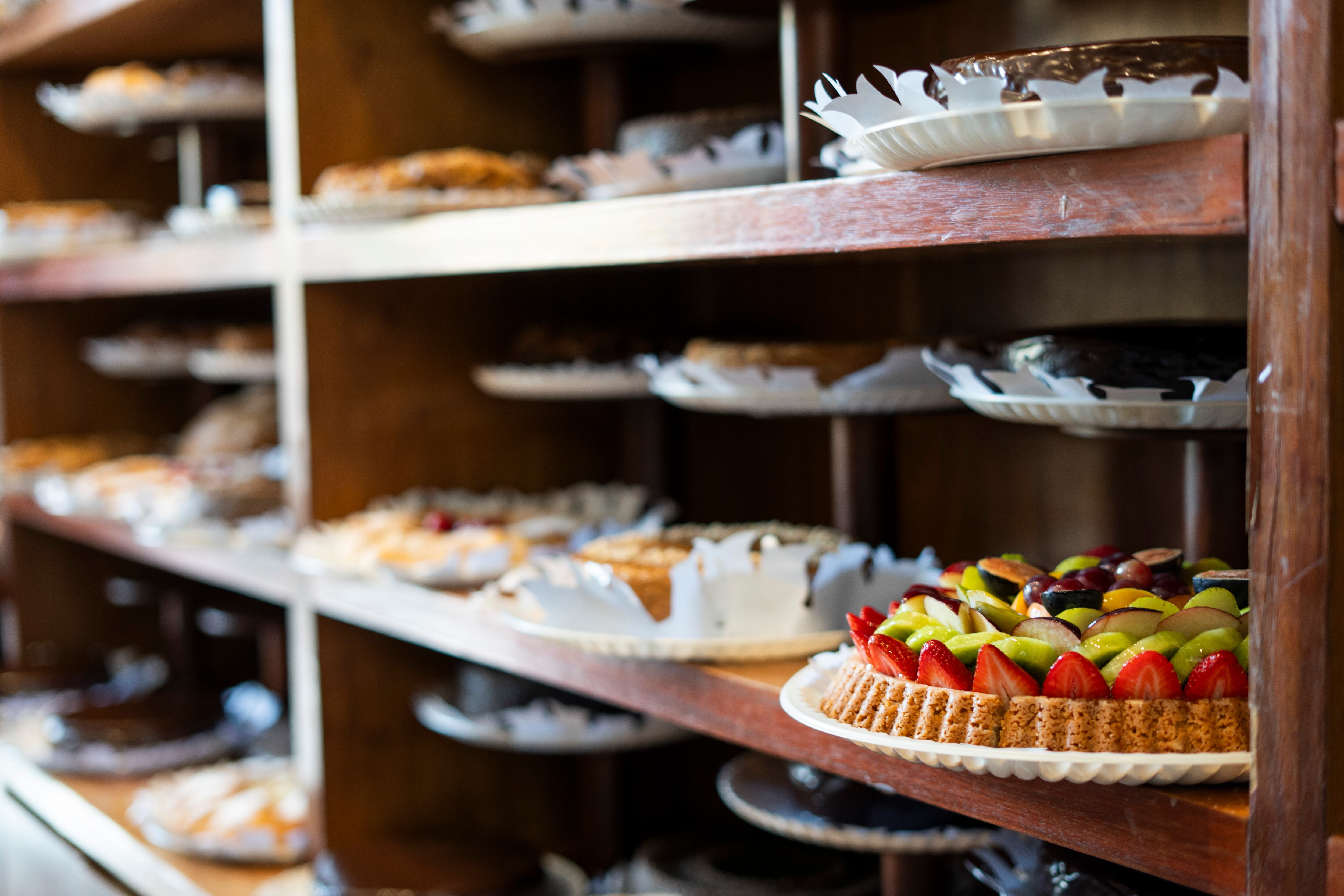 Tartas y pasteles expuestos en una estantería de Los Tulipanes.