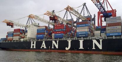 Un buque de carga de la naviera Hanjin bajo varias gr&uacute;as durante el proceso de carga en el puerto de Hamburgo.