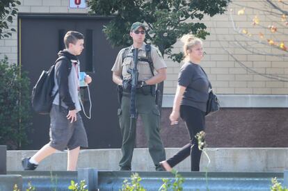 FOX LAKE, IL - SEPTEMBER 01: An Illinois State Police officer stands guard outside Grant High School as parents arrive to pick up their children while nearby, police continued to search for suspects involved in the shooting death of a police officer September 1, 2015 in Fox Lake, Illinois. The school, only blocks from the search area, remained on lockdown for most of the day. Police are searching for three suspects who killed the officer from the Fox Lake Police Department this morning.   Scott Olson/Getty Images/AFP