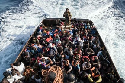 Un guardacosta líbio vigila a los 147 inmigrantes ilegales que intentaban llegar a Europa desde la ciudad costera de Zawiyah, a 45 kilómetros al oeste de la capital, Trípoli, el 27 de junio de 2017.