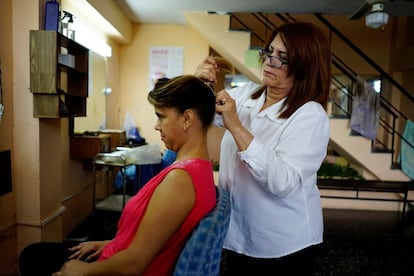 La estilista Sandra Hernández usa un preservativo para atar el pelo de una clienta en su peluquería de La Habana (Cuba).