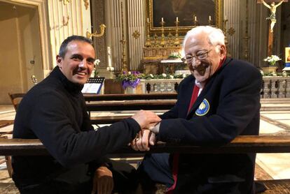 Giovanni Cerri, rector de la iglesia de los Santísimos Estigmas de San Francisco, toma las manos del padre Ángel.