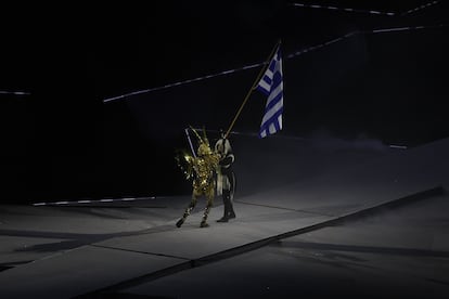 La amazona  pasa la bandera nacional de Grecia al Viajero Dorado mientras se lleva a cabo un espectáculo de luces durante la Ceremonia de Clausura de los Juegos Olímpicos de París 2024.