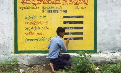 El estudiante Vamshi Voggu apunta los datos obtenidos de una estación automática de medición de agua en un muro de las afueras del instituto de Kothapally, India, el 31 de julio de 2019.