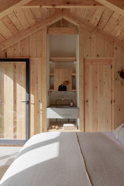 El interior de la cabaña anexa se ha revestido en madera de pino. La cama, diseño de los arquitectos, también está hecha en madera de pino. La ropa de cama es de Teixidors.