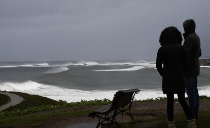 Una pareja contempla el espectáculo de las olas provocadas por el temporal en Ribadeo (Lugo).