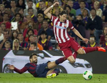 Piqu&eacute; lucha el bal&oacute;n con Filipe Luis.