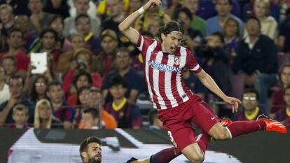 Piqué lucha el balón con Filipe Luis.