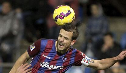 El defensa Txema Añibarro despeja una pelota de cabeza.