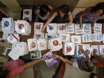 Padres y madres de un colegio p&uacute;blico preparan los libros que han comprado por cooperativa.