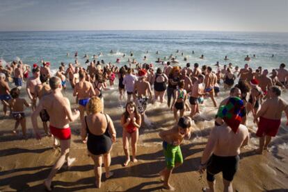 Bañistas de casi todas las edades se dan el primer baño del año en la Barceloneta.