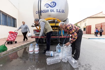 Varios vecinos llenan garrafas de agua en Humilladero, este jueves. 