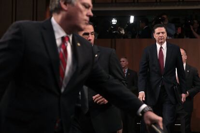 El exdirector del FBI James Comey llega a la sala para testificiar.