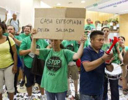 Decenas de miembros de la Plataforma de Afectados por la Hipoteca (PAH), se concentran en el interior de una sucursal de Catalunya Caixa, situada en la barcelonesa calle Provenza, para exigir la dación en pago de todos los desahucios instados por esta entidad bancaria. EFE/Toni Garriga