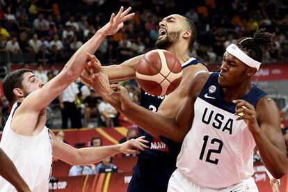 El jugador francés Rudy Gobert (en el centro) lucha por la pelota junto con Joe Harris (a la izquierda) y Myles Turner.