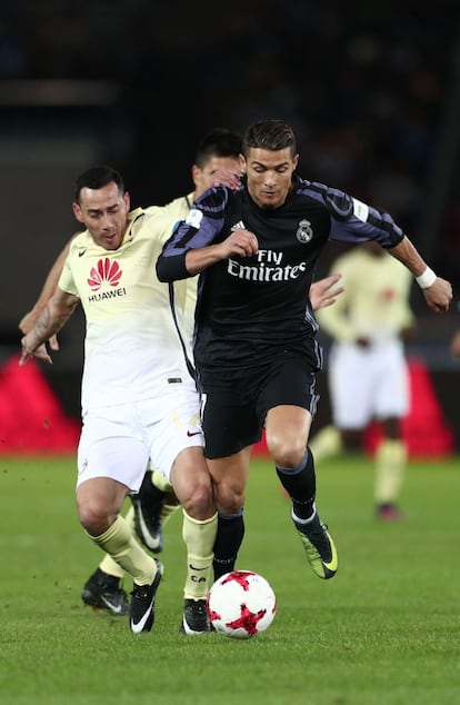 Cristiano Ronaldo (d), del Real Madrid, lucha por el balón junto con Rubens Sambueza (i), del Club América.