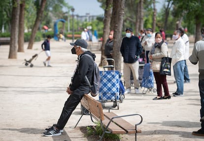 Los vecinos esperan el reparto de comida este sábado en la Asociación de Vecinos de Aluche. 
