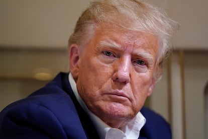 Former president Donald Trump listens as he speaks with reporters while in flight on his plane after a campaign rally at Waco Regional Airport