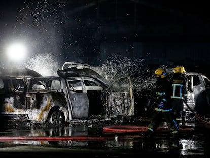 Três bombeiros apagam um incêndio provocado durante os protestos da noite de 14 de julho em Santiago.