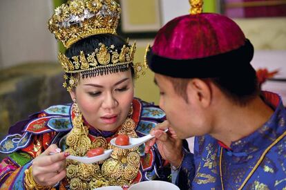 Una pareja come sopa dulce con bolas de arroz en la ceremonia de su boda 
 Baba Nyonya en Malasia. 