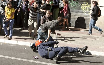 Un agente de la Ertzaintza cae al tratar de detener a un manifestante en una multitudinaria manifestación celebrada hoy en Vitoria y que ha registrado algunas cargas policiales