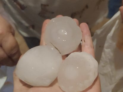 Una persona enseña algunas de las piedras de hielo que cayeron ayer en La Bisbal.