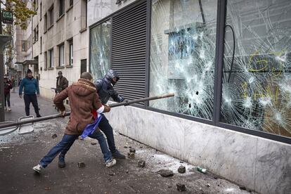 Dos jóvenes rompen los cristales de una sucursal del banco HSBC, en la plaza de Italia en París, durante las protestas de los 'chalecos amarillos' este sábado.