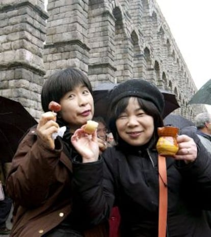 Dos turistas japonesas disfrutan de la gastronomía típica en Segovia.