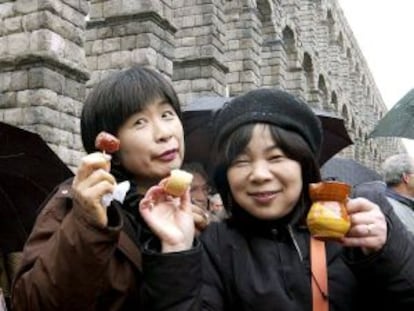 Dos turistas japonesas disfrutan de la gastronomía típica en Segovia.