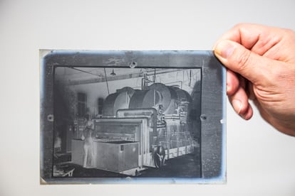 Placa de vidrio en la que se fotografió a un operario de la fábrica trabajando con una máquina.