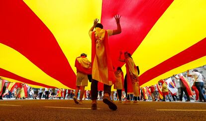 Manifestantes debajo de una enorme bandera catalana durante la manifestación de la fiesta nacional.