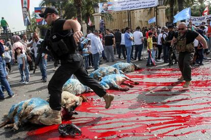 Miembros de las fuerzas de seguridad libanesas saltan a través de la sangre que fluye de ovejas sacrificadas (pintadas de azul por el color del Movimiento Futuro del Primer Ministro) durante una manifestación de campaña y una recepción del primer ministro en la ciudad portuaria sureña de Sidón.