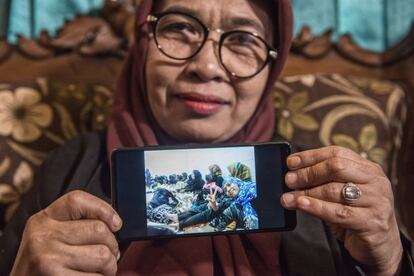 Jejen Nurjanah es la fundadora de la ONG local Serikat Buruh Migran Indonesia, una organización que da apoyo a cientos de mujeres. La activista posa con una fotografía de varias empleadas domésticas indonesias esperando a ser deportadas de Arabia Saudí.