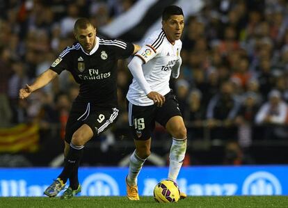 Enzo Pérez conduce el balón, ante la mirada de Benzema.