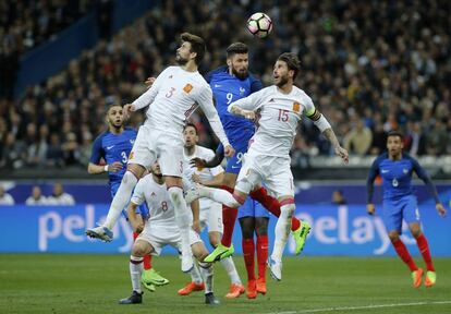 Piqué y Ramos saltan junto a Giroud durante el Francia-España.