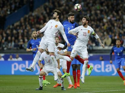Piqu&eacute; y Ramos saltan junto a Giroud durante el Francia-Espa&ntilde;a.