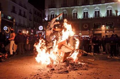 Un grupo de antisistema enciende una hoguera en la Puerta del Sol para protestar por los resultados electorales.
