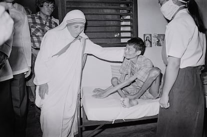 Teresa de Calcuta acaricia a un enfermo, que sufre de polio, en Manila, el 27 de noviembre de 1982. 