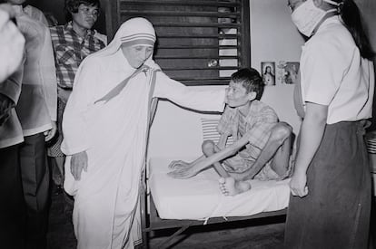 Teresa de Calcuta acaricia a un enfermo, que sufre de polio, en Manila, el 27 de noviembre de 1982.