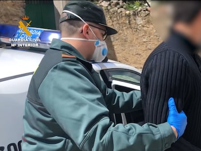 Un agente de la Guardia Civil custodia a uno de los tres detenidos.
