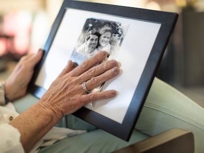 Una mujer mirando una fotografía de su familia.