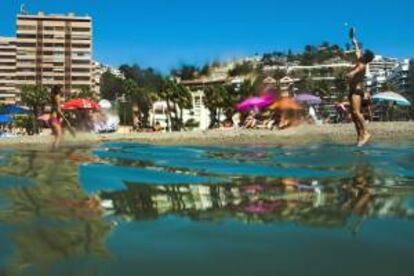 Una pareja disfruta jugando a las palas en la playa de la Caleta en Málaga.