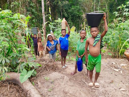 Varios niños baka transportan agua en el pueblo camerunés de Mimbril. La construcción de una presa dejó a esta comunidad con el movimiento limitado, y eso afectó a los niños, que no podían ir a la escuela.