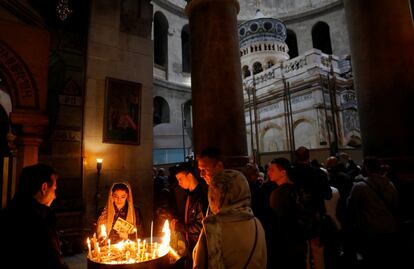 Todos coinciden, sin dudarlo, en que el momento más emotivo de estos meses de trabajo fue cuando retiraron la lápida del sepulcro donde la tradición cristiana sitúa los restos de Jesucristo. En la imagen, devotos encienden velas cerca del edículo recién restaurado, en Jerusalén.