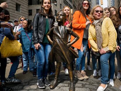 Turistas ante la escultura en bronce de la