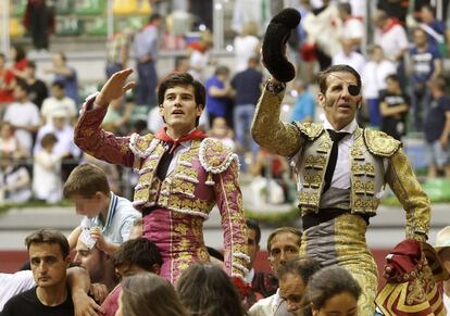 Los diestros Jos&eacute; Garrido (izquierda) y Juan Jos&eacute; Padilla salen ayer martes a hombros tras el cuarto festejo taurino de la feria de San Pedro y San Pablo de Burgos.