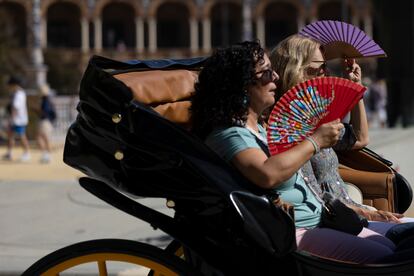 Dos turistas se abanican en una calesa, este jueves en Sevilla, donde se rozaron ya los 37 grados.